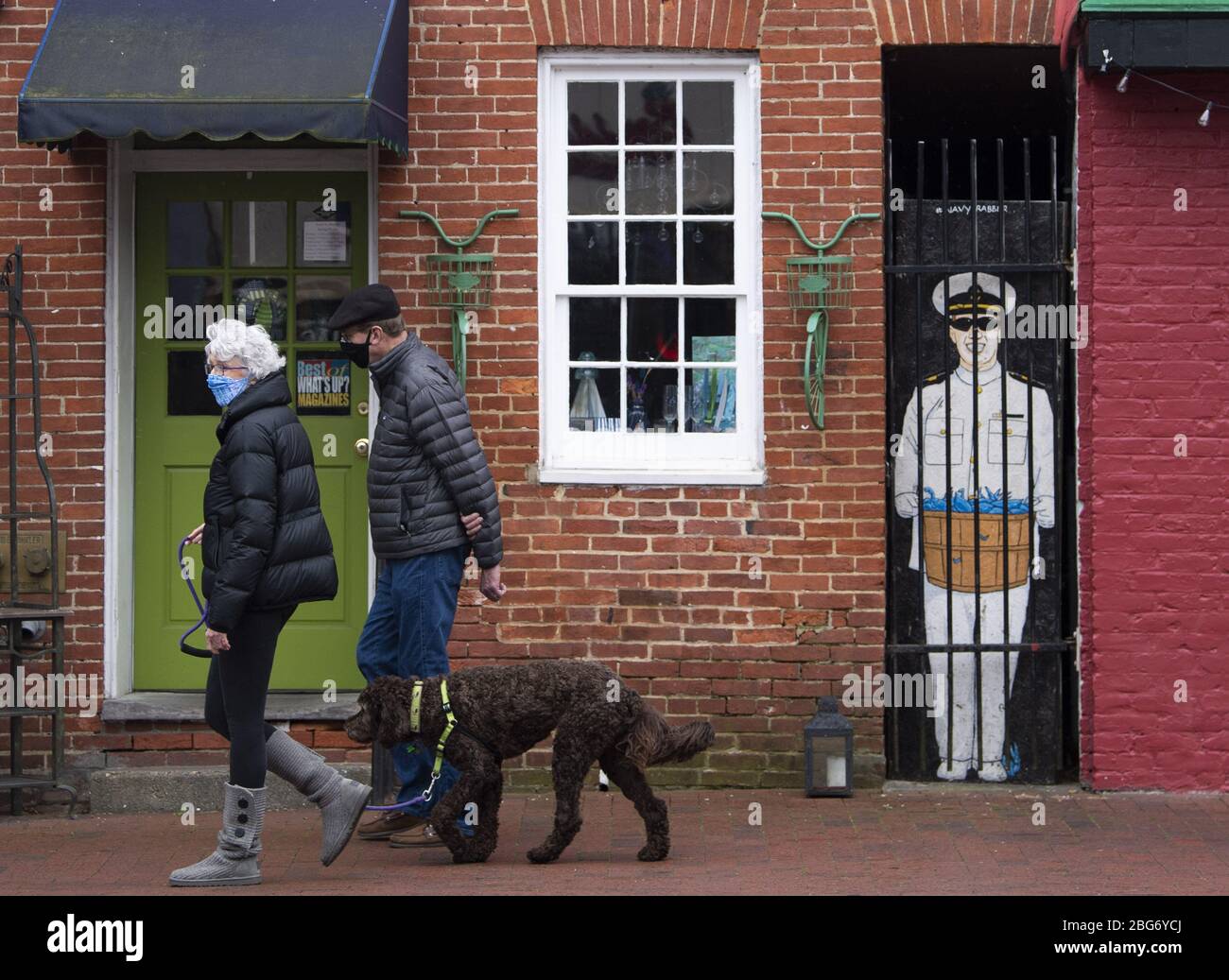 Annapolis, United States. 20th Apr, 2020. People wear masks as they walk a dog on Main Street in downtown Annapolis, Maryland amid the Coronavirus COVID-19 pandemic on Monday, April 20, 2020. Gov. Larry Hogan, R-MD, recently passed an order that requires all people must wear a face covering before going into any retail establishment.  Photo by Kevin Dietsch/UPI Stock Photo