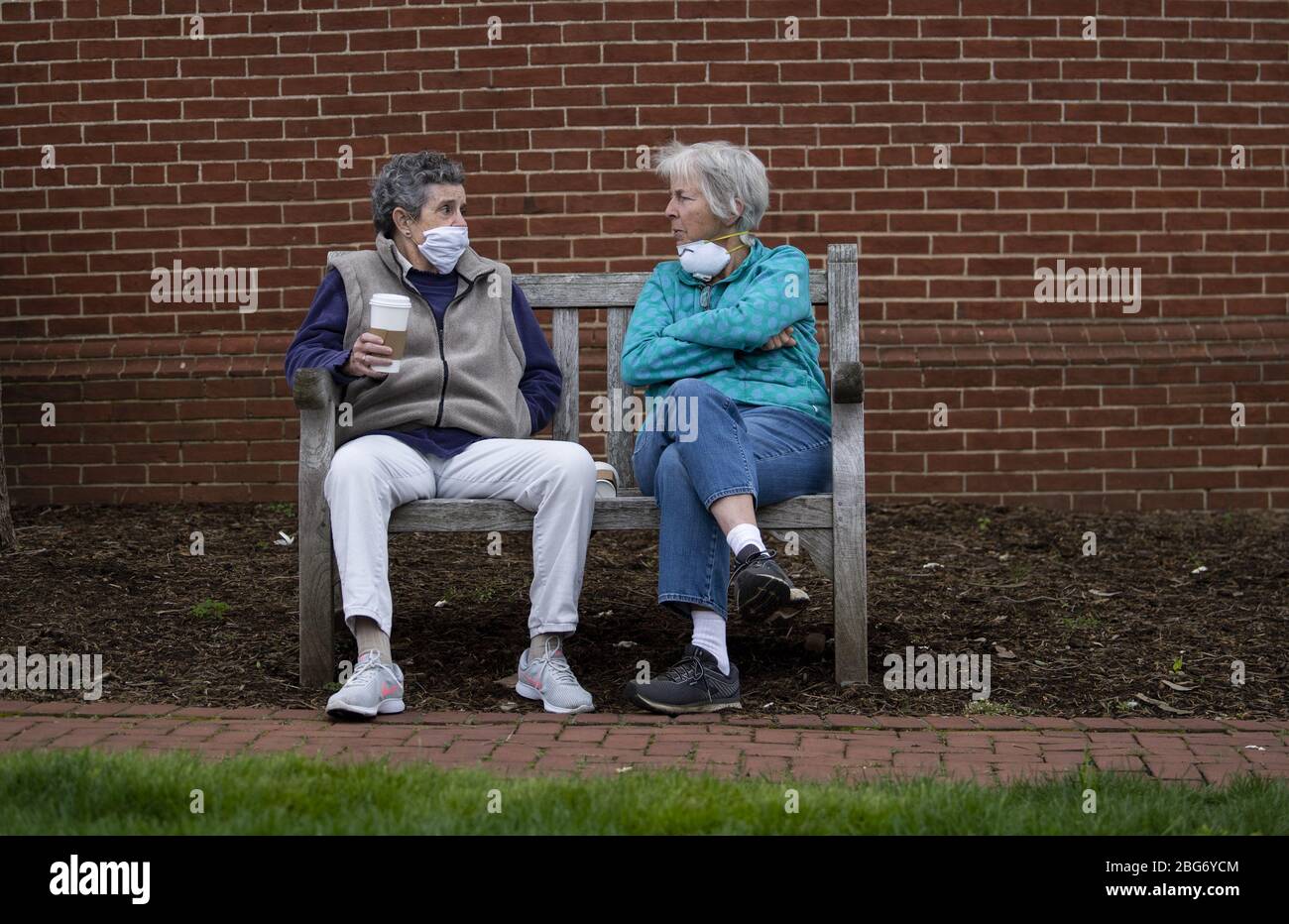 Annapolis, United States. 20th Apr, 2020. People wears masks as they sit on a bench in downtown Annapolis, Maryland amid the Coronavirus COVID-19 pandemic on Monday, April 20, 2020. Gov. Larry Hogan, R-MD, recently passed an order that requires all people must wear a face covering before going into any retail establishment.  Photo by Kevin Dietsch/UPI Stock Photo