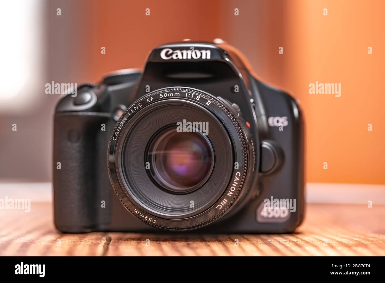 Norwich, Norfolk, UK – April 19 2020. Front on view of classic Canon EOS 450d dslr camera and 50mm f1.8 prime lens. Selective focus on the lens with Stock Photo