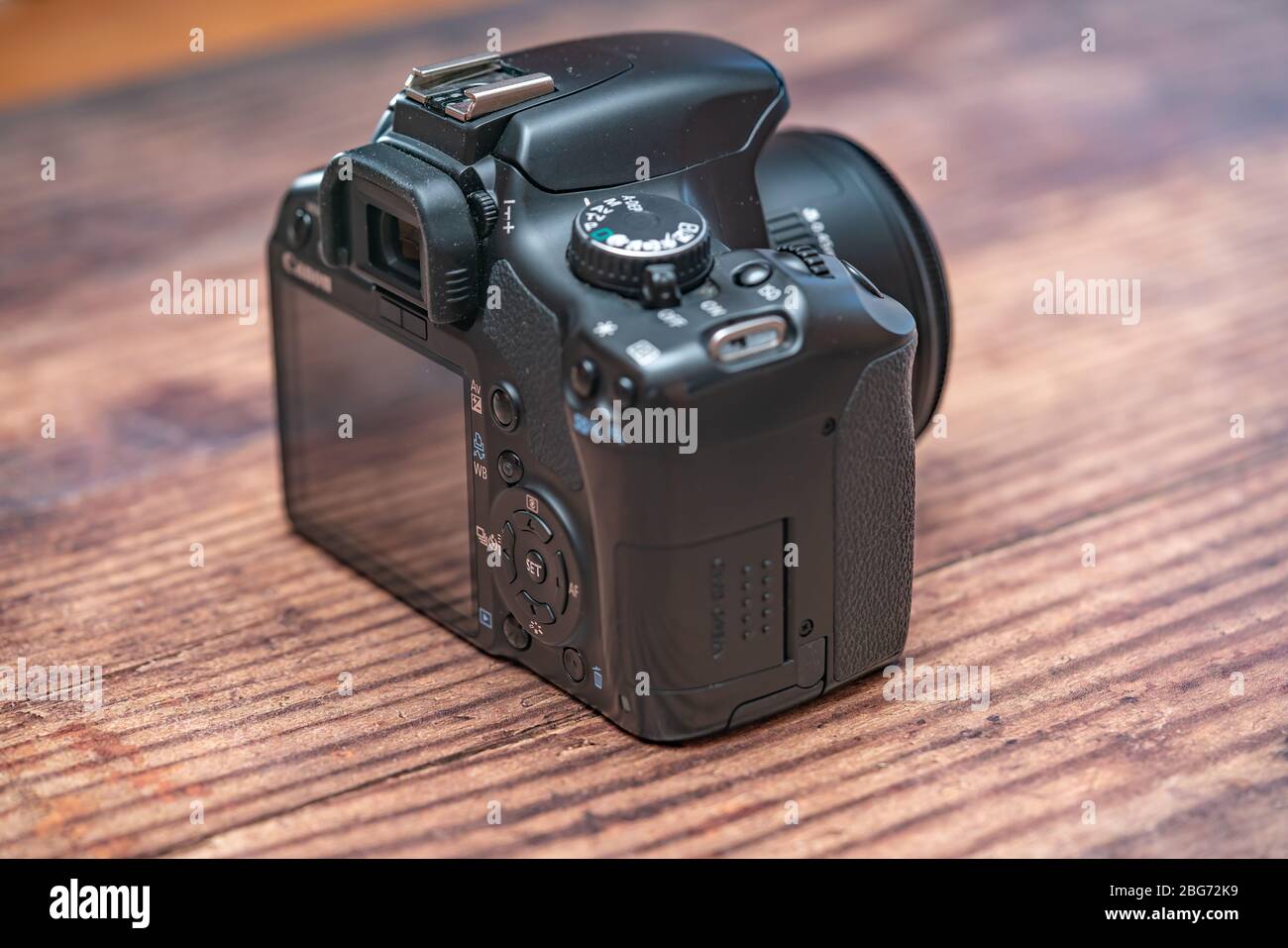 Norwich, Norfolk, UK – April 19 2020. The rear of a classic Canon EOS dslr camera on a wooden background with intentional close and selective focus Stock Photo