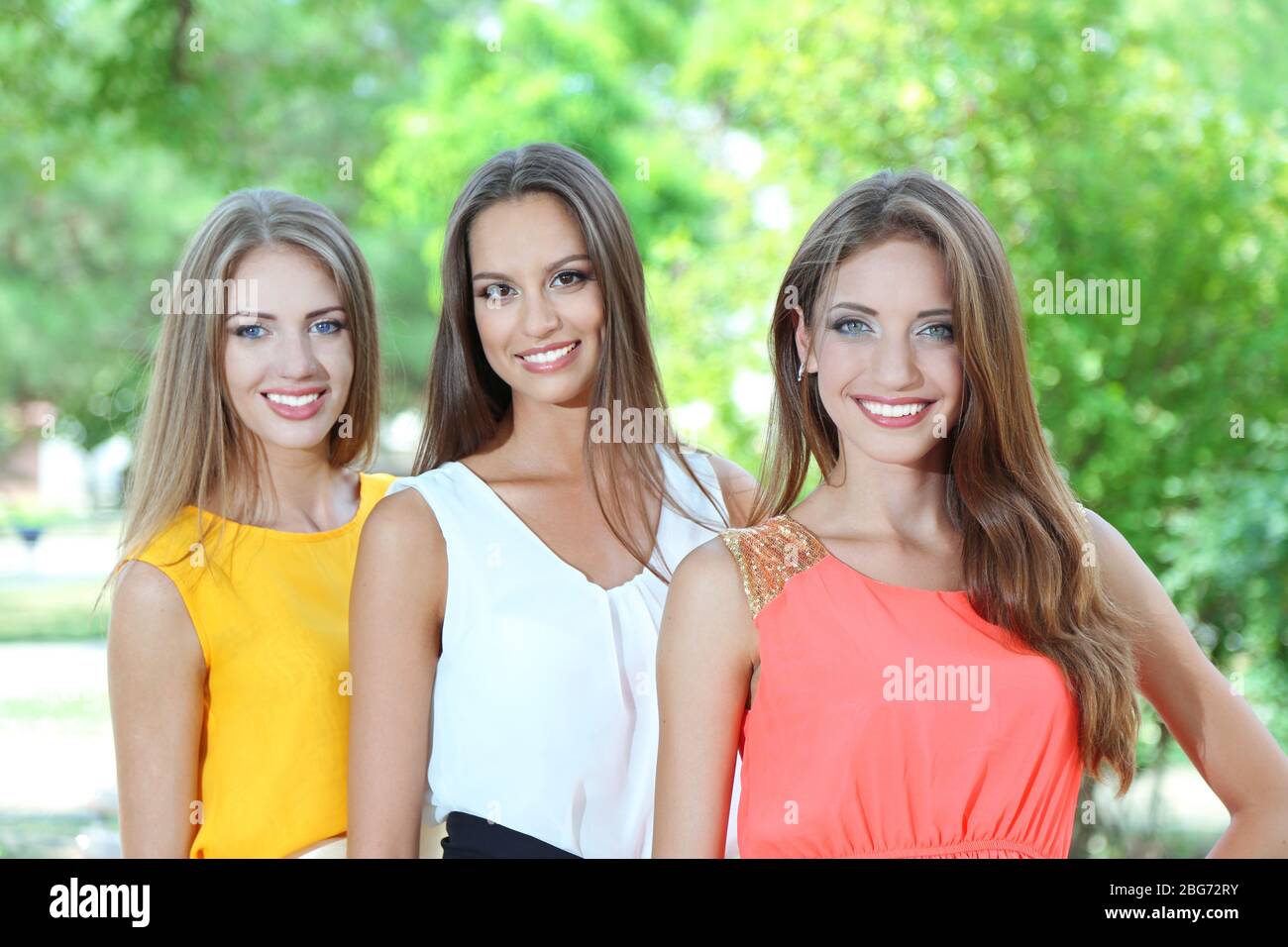 Three beautiful young woman in summer park Stock Photo - Alamy