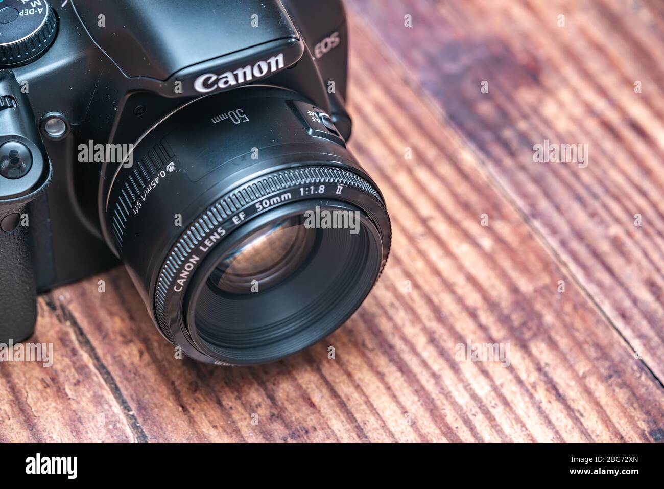 Norwich, Norfolk, UK – April 19 2020. Close up and top down view of a classic Canon EOS dslr camera on a wooden table with close and selective focus Stock Photo