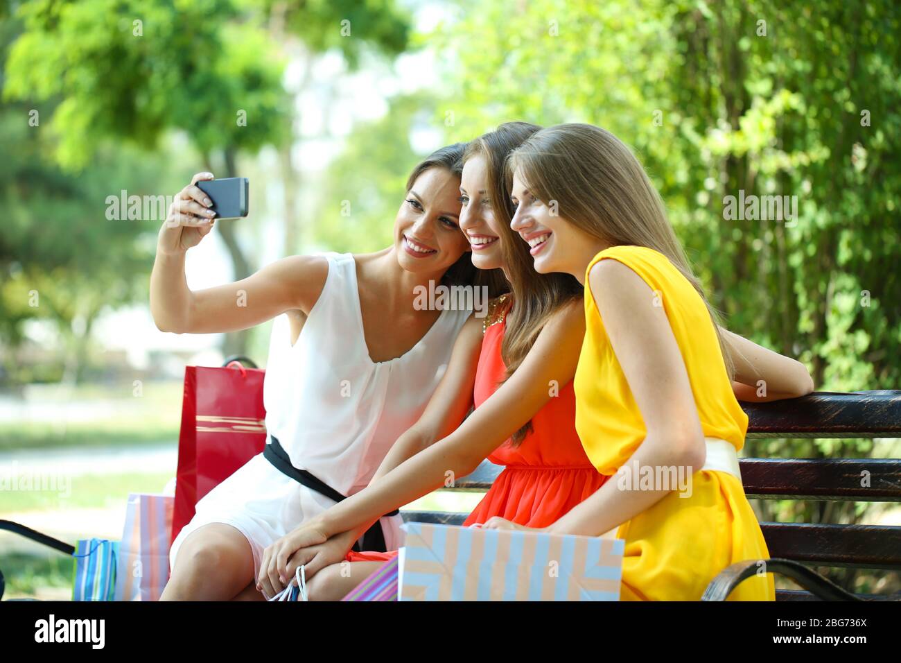 Three beautiful young woman taking picture in summer park Stock Photo ...