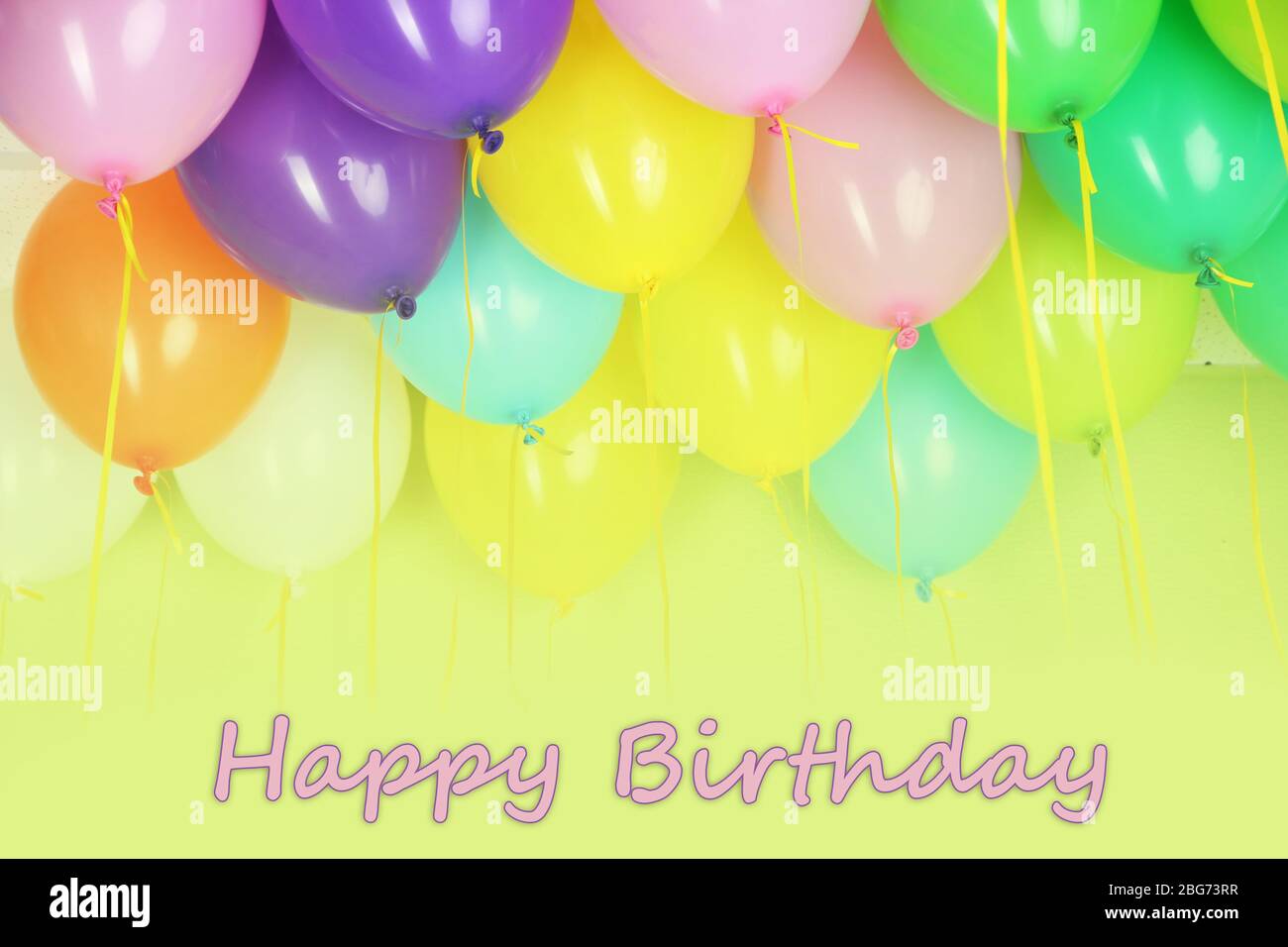 Colorful balloons on green wall background Stock Photo - Alamy