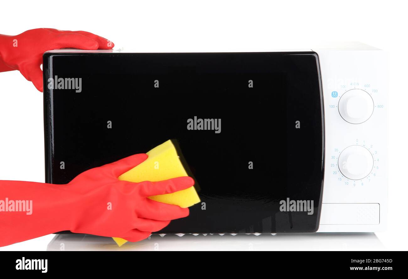 Hand with sponge cleaning microwave oven, isolated on white Stock Photo