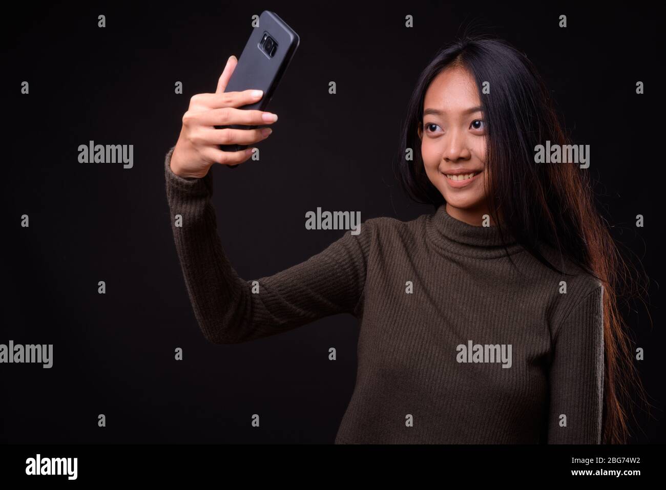 Happy young beautiful Asian woman taking selfie Stock Photo - Alamy