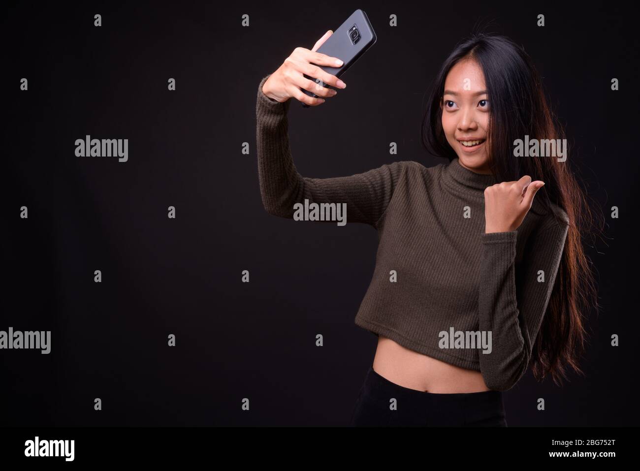 Happy young beautiful Asian woman taking selfie Stock Photo - Alamy