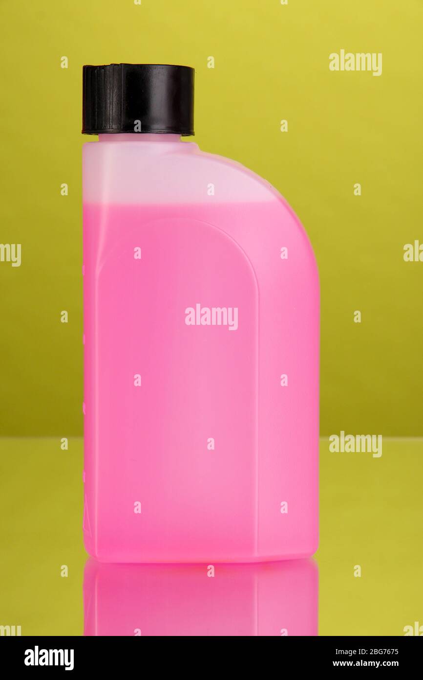 Pink liquid for car in canister on green background Stock Photo