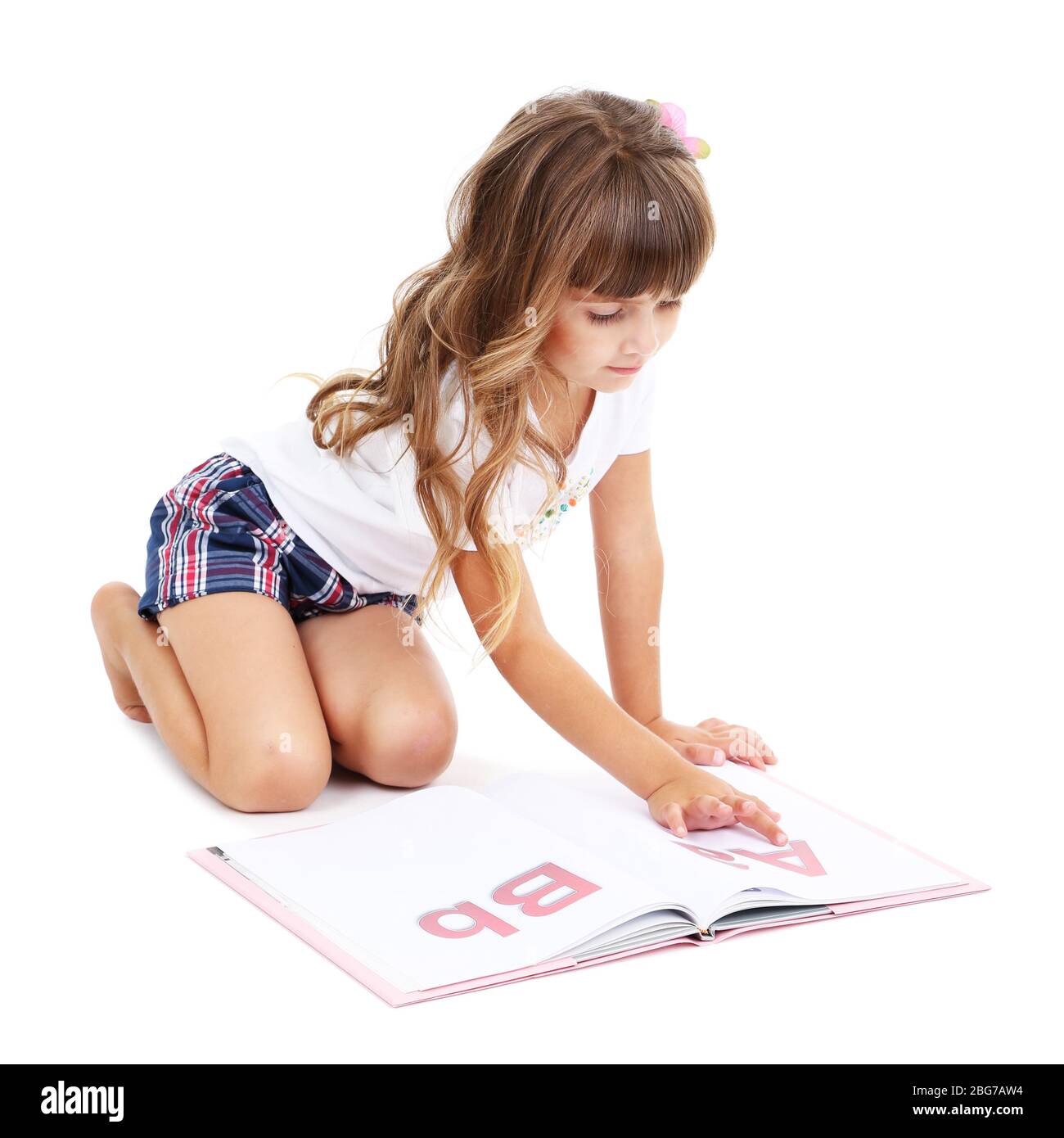 Little girl sitting on floor with book isolated on white Stock Photo ...