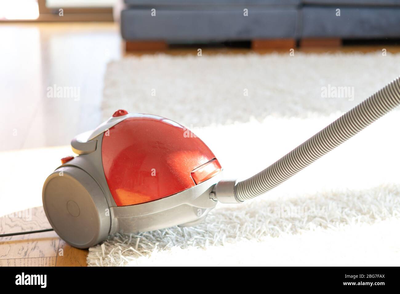 Cleaning floor and carpet with vacuum cleaner Stock Photo - Alamy