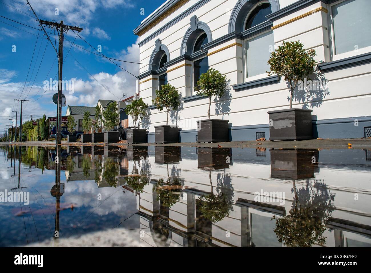 Historic building reflections in a kerb side rain puddle after a bad ...