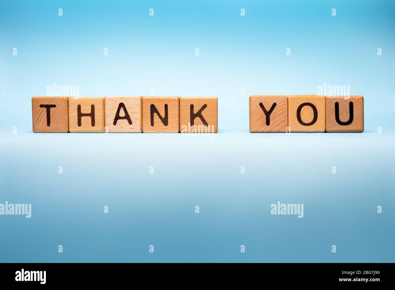 Thank you on blue medical background. Thank you made with cubes. Message of gratitude thanks to helpers. Symbol of hope during Covid-19 outbreak Stock Photo