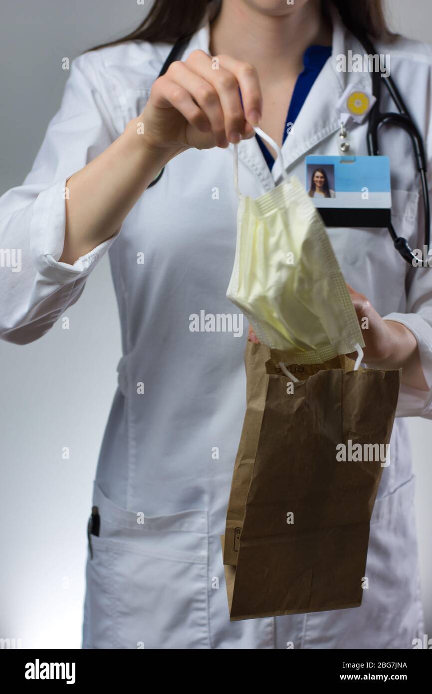 Female healthcare worker demonstrating bagging of mask for coronavirus