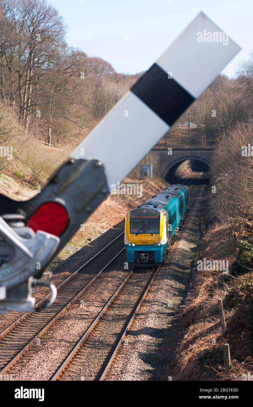 Arriva trains Wales / Transport For Wales class 175 Alstom coradia train 175105 with an upper quadrant semaphore home signal at Frodsham, Cheshire Stock Photo