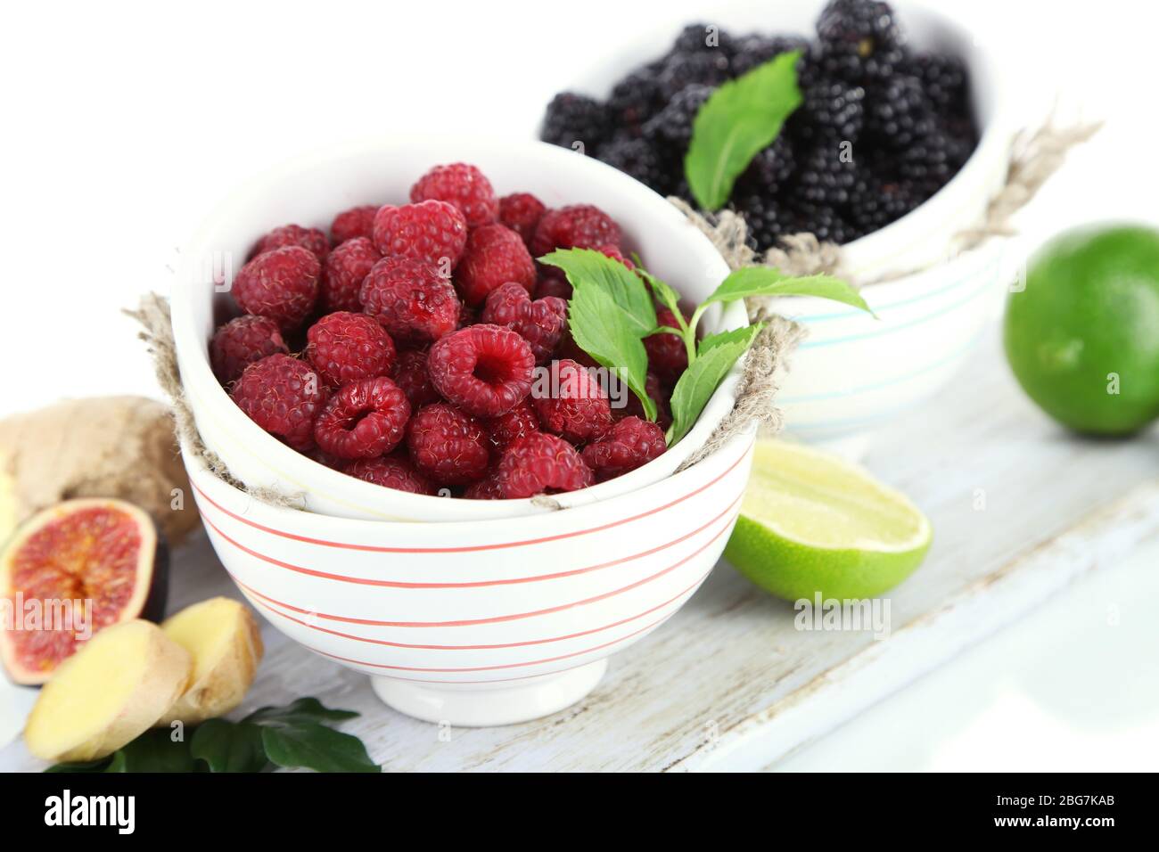 Mer Raspberry Blackberry Raspberries and blackberry in small bowls on board isolated on white ...