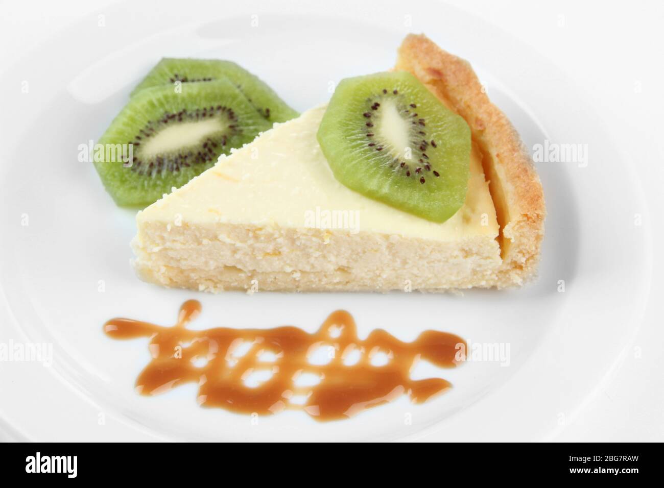 Slice of cheesecake with kiwi fruit and caramel sauce on plate