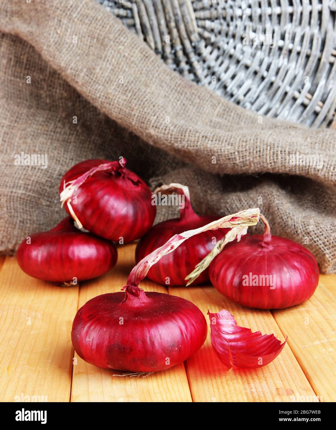 Fresh red onions on wooden table Stock Photo - Alamy