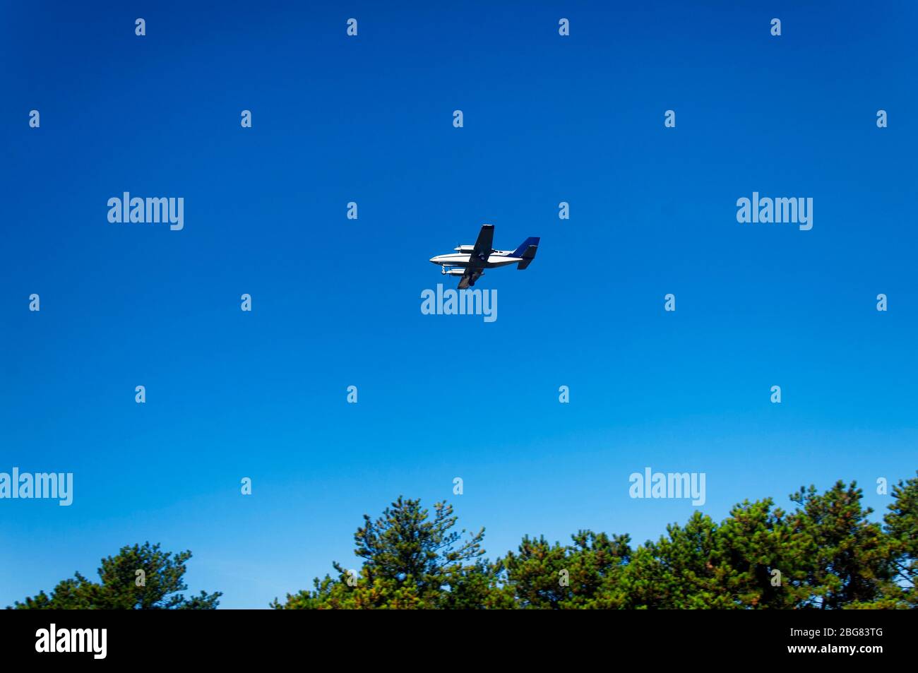 A small aircraft flying over the national seashore coming in for a landing at the cape cod airport in Massachusetts. Stock Photo
