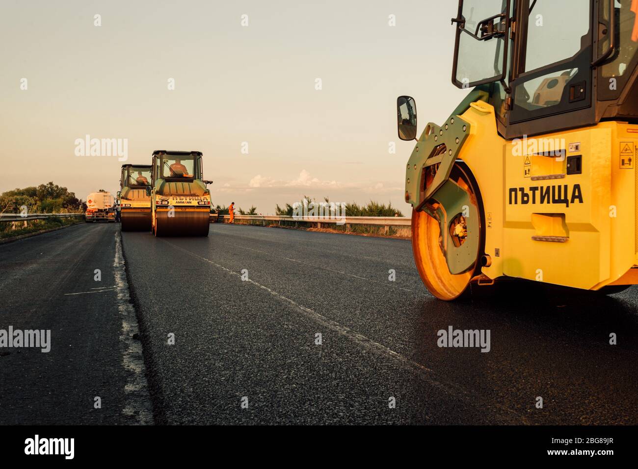 road roller applying a new asphalt surface. asphalt paving construction site on a highway  road construction and asphalting with machine Stock Photo