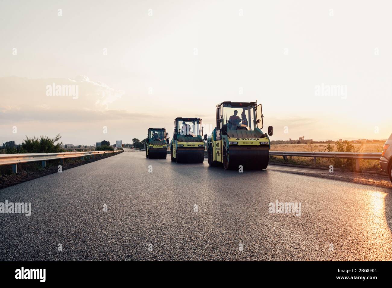 road roller applying a new asphalt surface. asphalt paving construction site on a highway  road construction and asphalting with machine Stock Photo