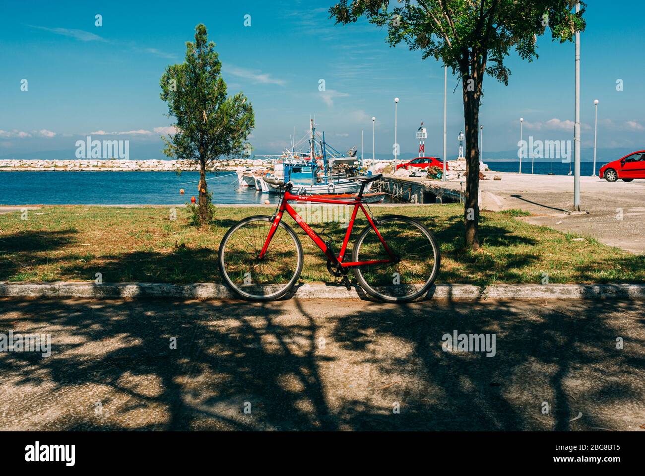 Road cycling photo. Red singlespeed fixed gear bike standing beside Mediterranean sea at Thassos, Greece Stock Photo