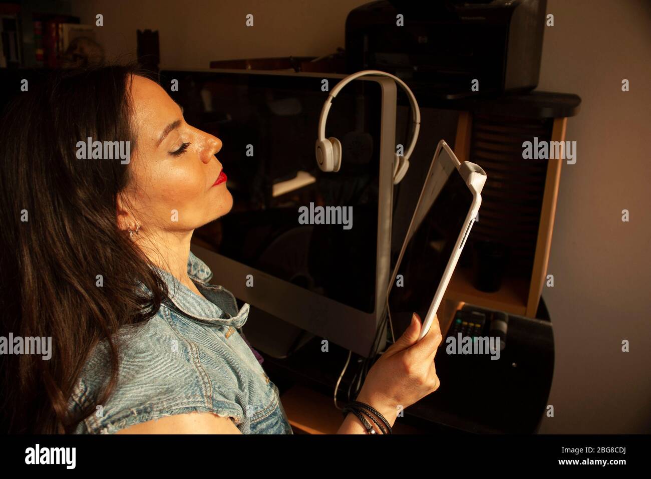 The home office work of a Caucasian woman between 40 to 45 years old in Mexico City using technological devices Stock Photo