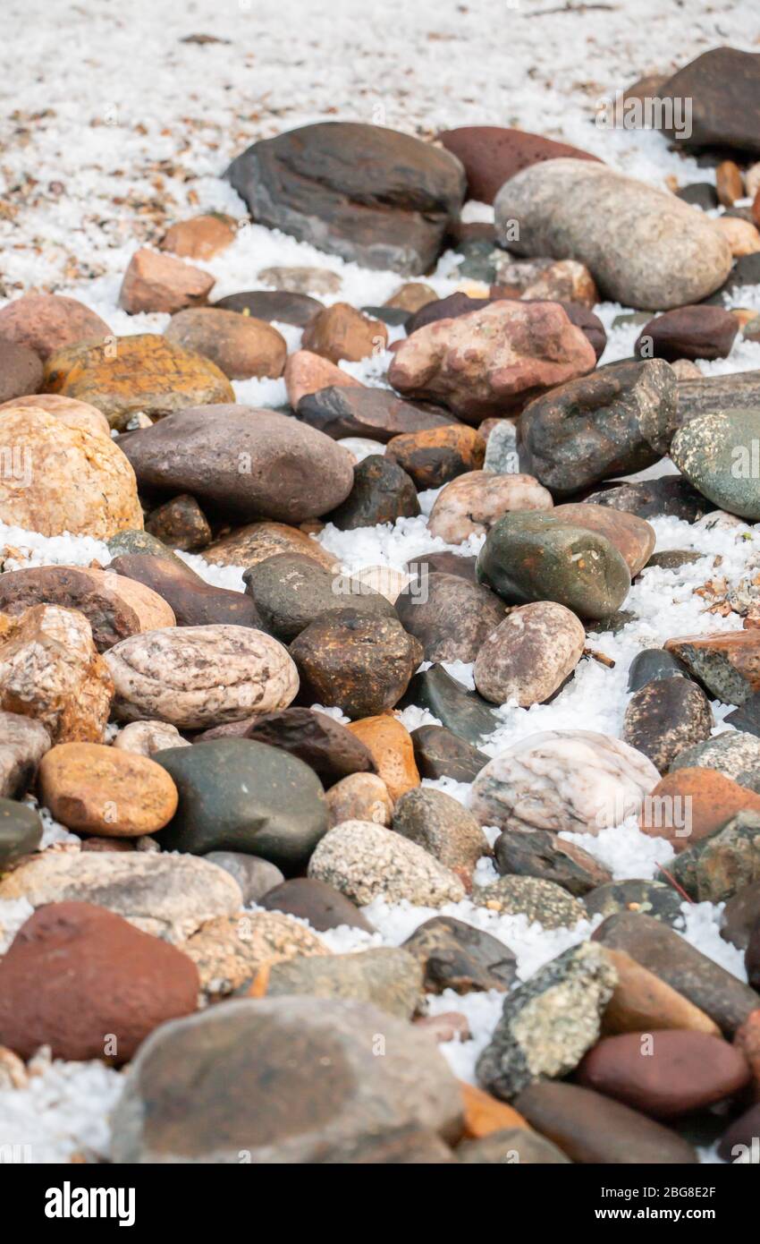 Hail in riverbed of rocks Stock Photo