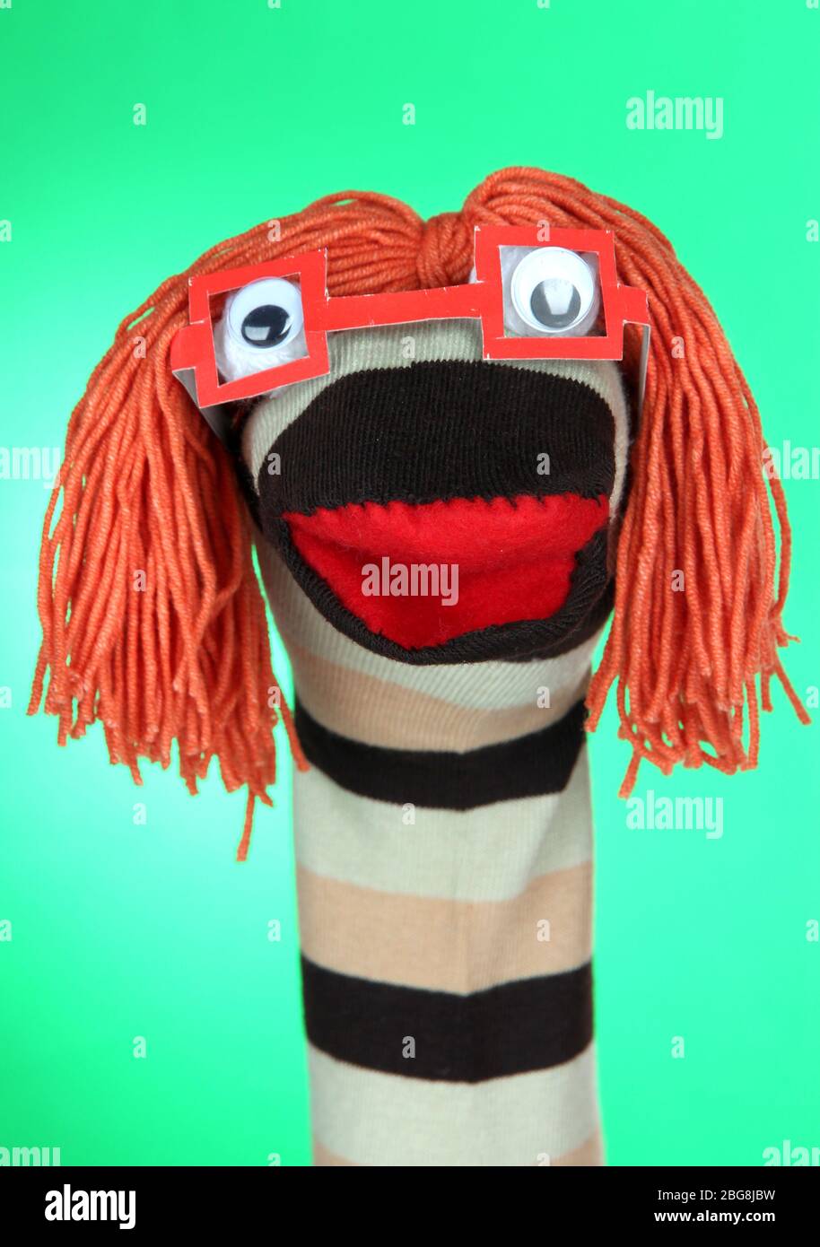 Cute sock puppet on green background Stock Photo - Alamy