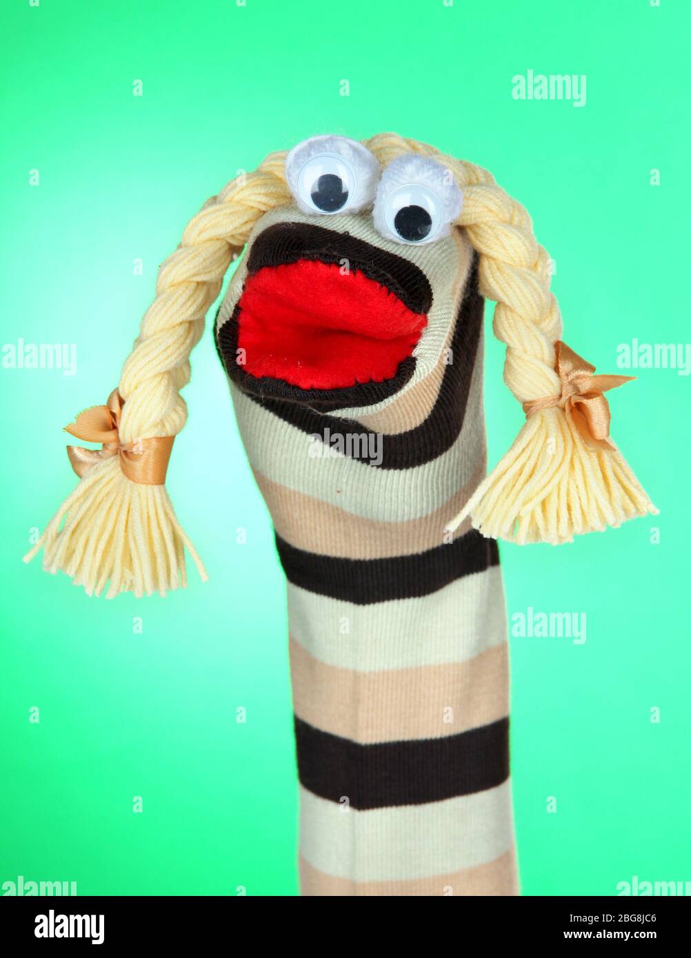 Cute sock puppet on green background Stock Photo - Alamy