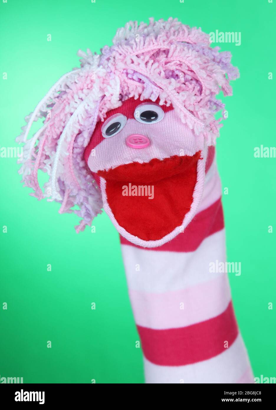 Cute sock puppet on green background Stock Photo - Alamy