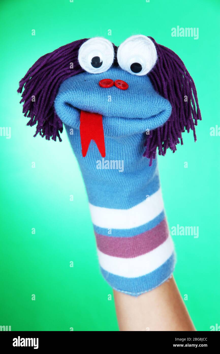 Cute sock puppet on green background Stock Photo - Alamy