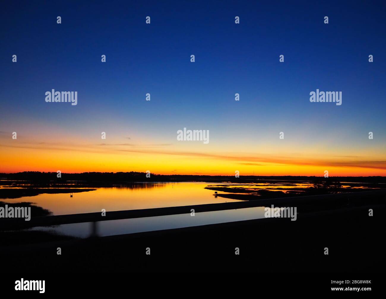The view over a marshy section of the Skidaway River near Savannah, Georgia from a bridge just after sunset on a winter evening. Stock Photo
