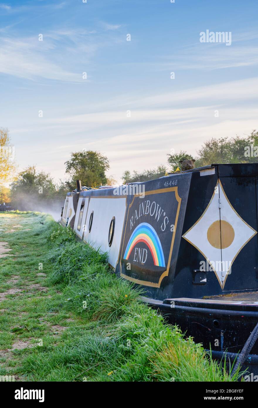 Canal boat called Rainbows End in the mist on the oxford canal on a spring morning at sunrise. Lower Heyford, Oxfordshire, England Stock Photo
