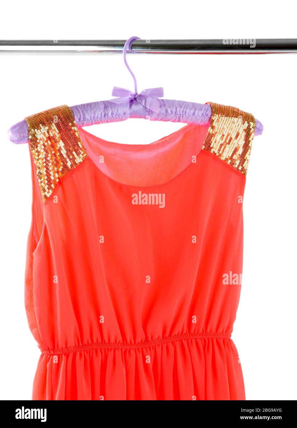 Beautiful coral dress hanging on hangers isolated on white Stock Photo