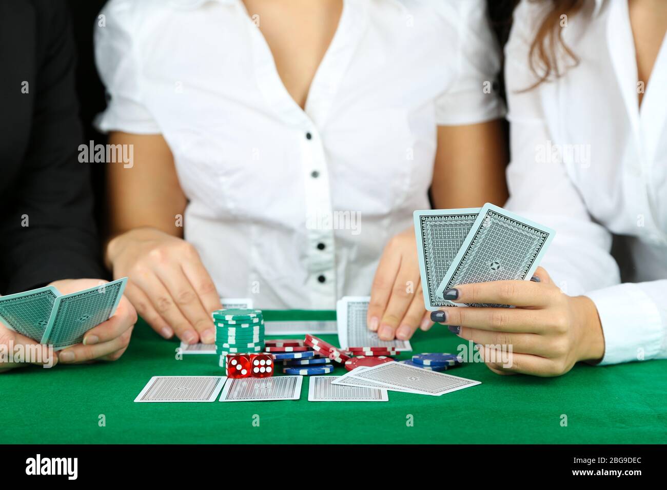 People playing cards at table Stock Photo