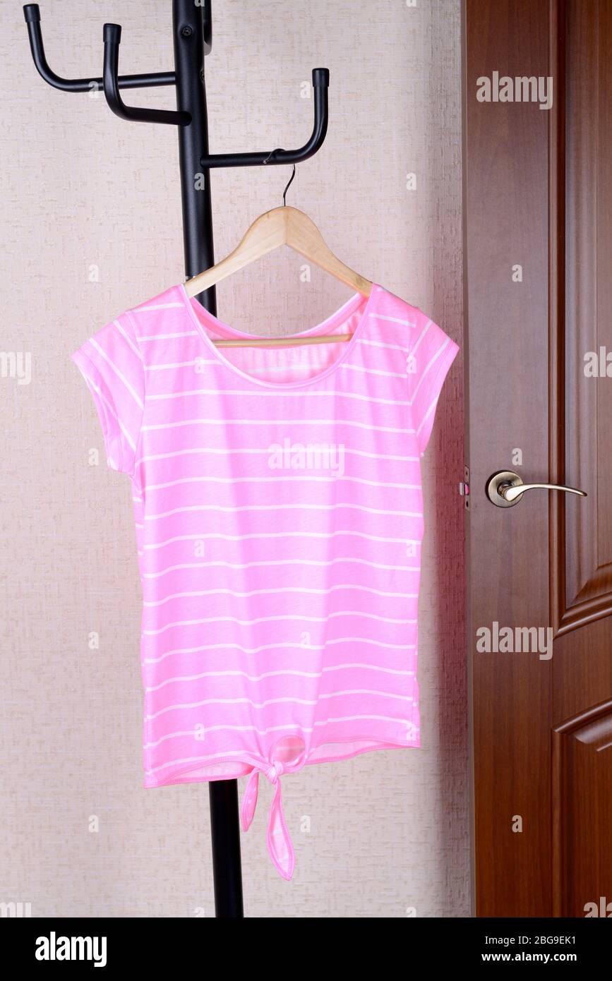 T-shirt hanging on hanger near door Stock Photo - Alamy