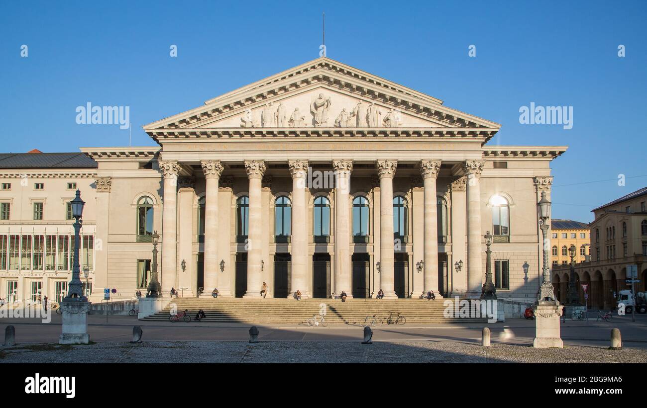 Bavarian State Opera, People sunning themselves on columns, Max-Joseph-Platz, Munich, Bavaria, Germany Stock Photo