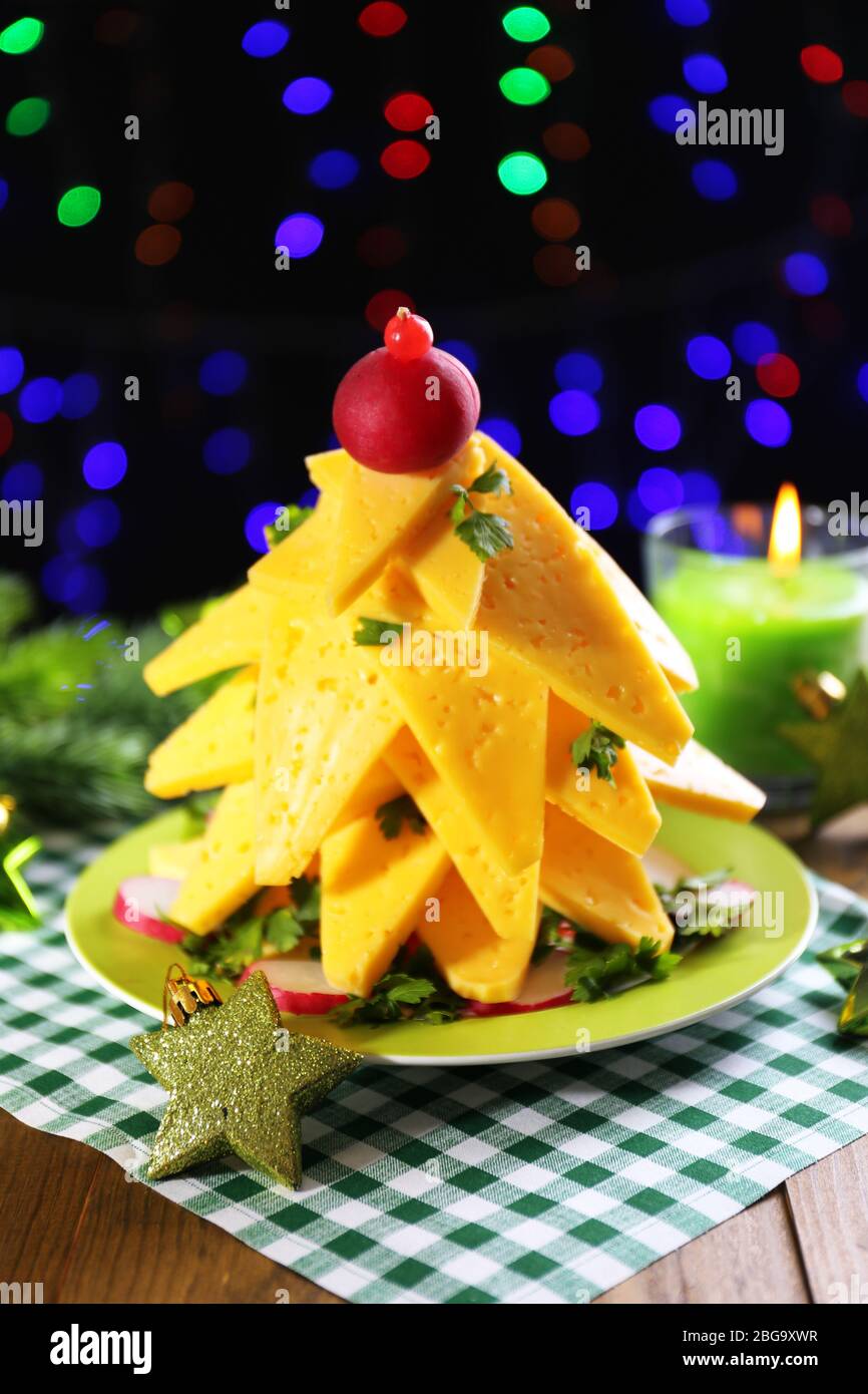 Christmas tree from cheese on table on dark background Stock Photo