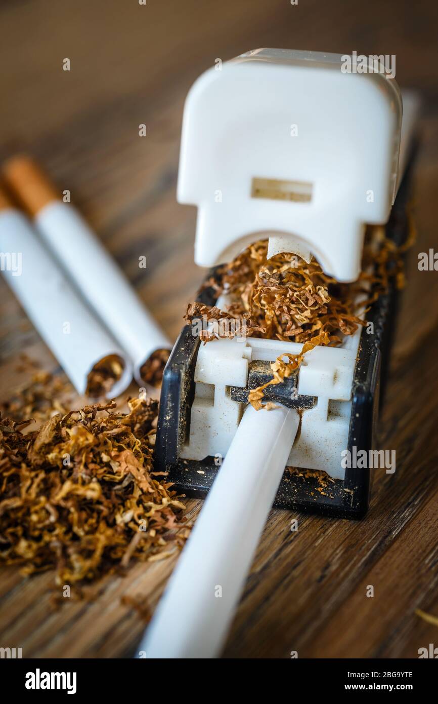 hand-made cigarettes at home using a manual machine Stock Photo