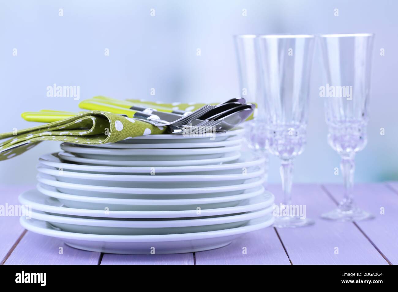 Clean dishes on wooden table on light background Stock Photo - Alamy