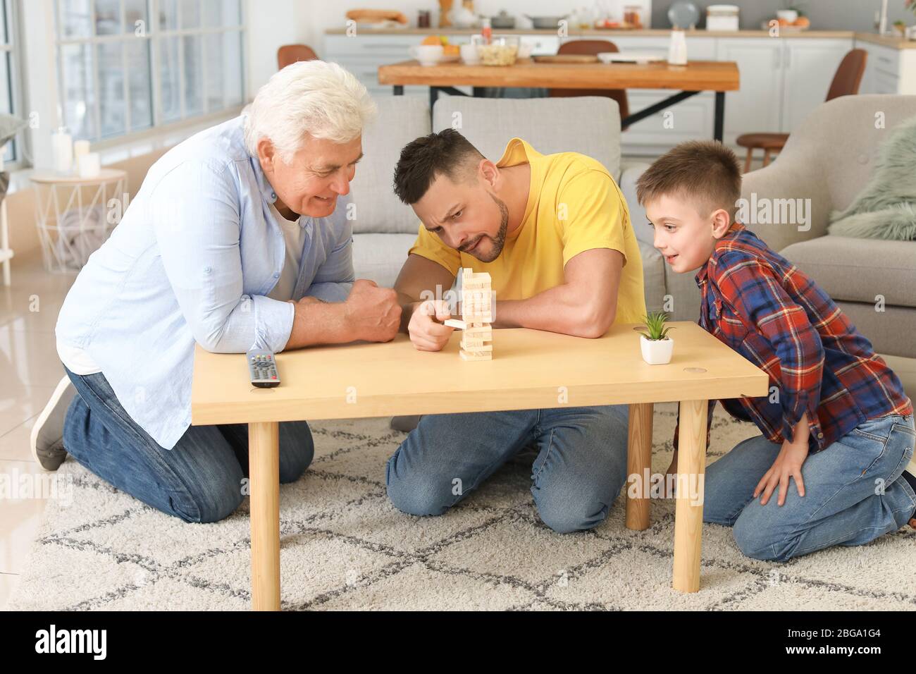 Man with his father and son spending time together at home Stock Photo