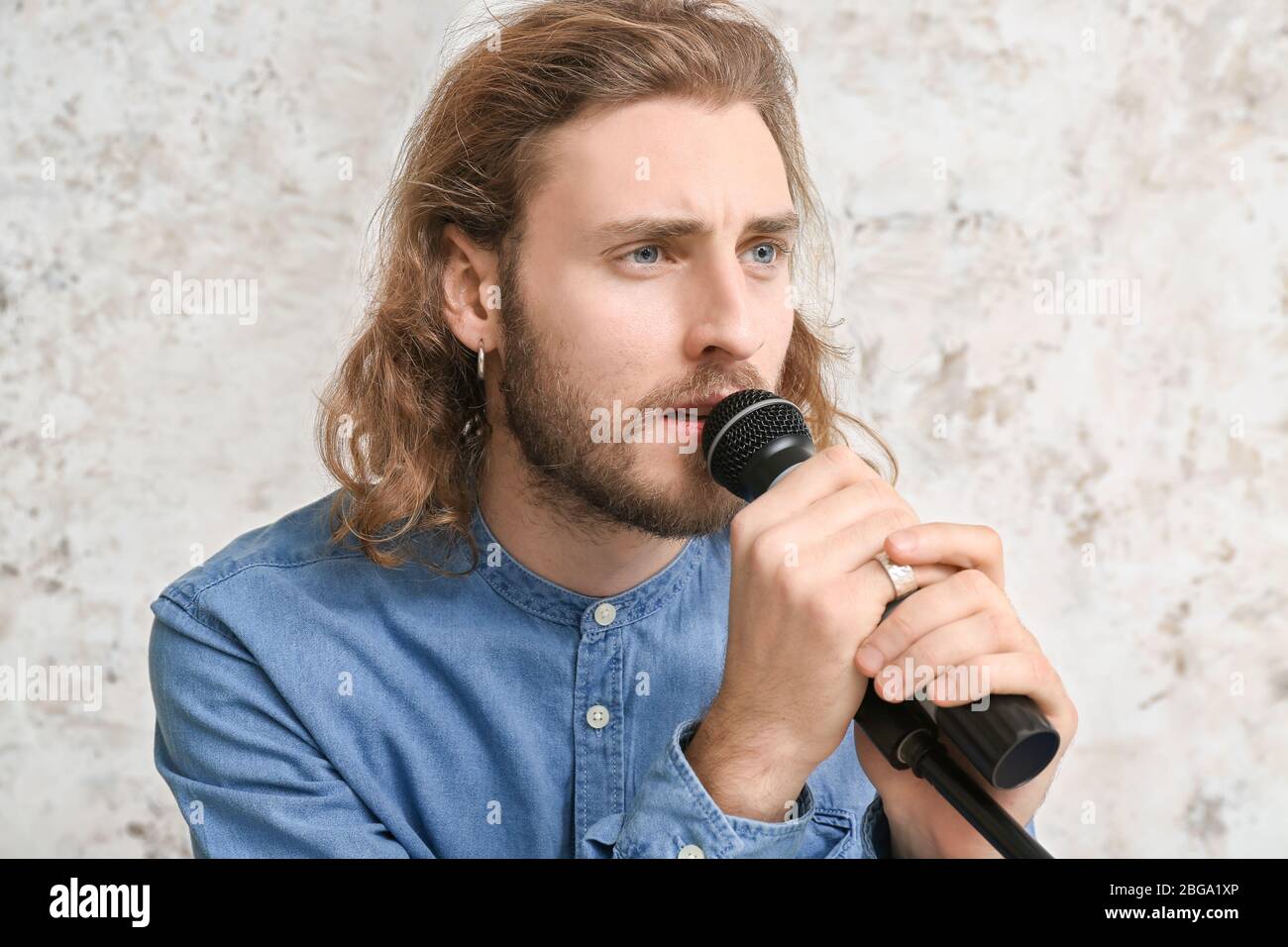 Young male singer on light background Stock Photo - Alamy