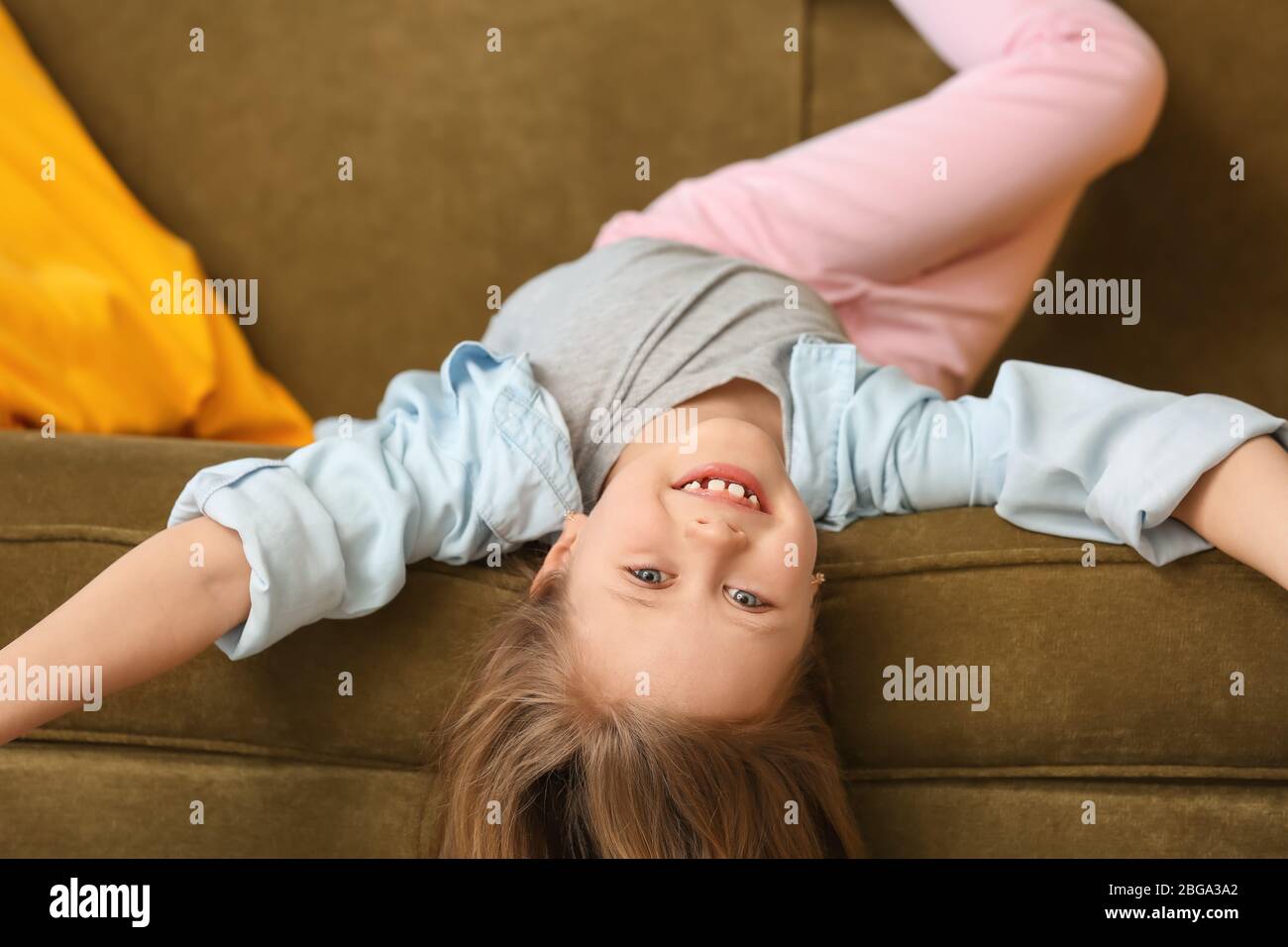 Cute little girl lying on sofa at home Stock Photo - Alamy
