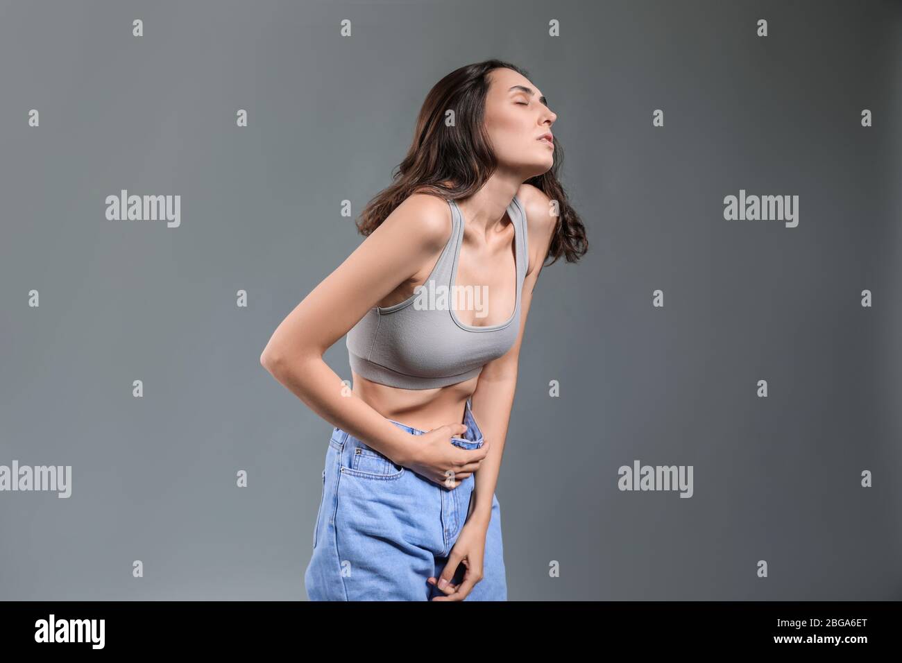 Young woman with anorexia on grey background Stock Photo