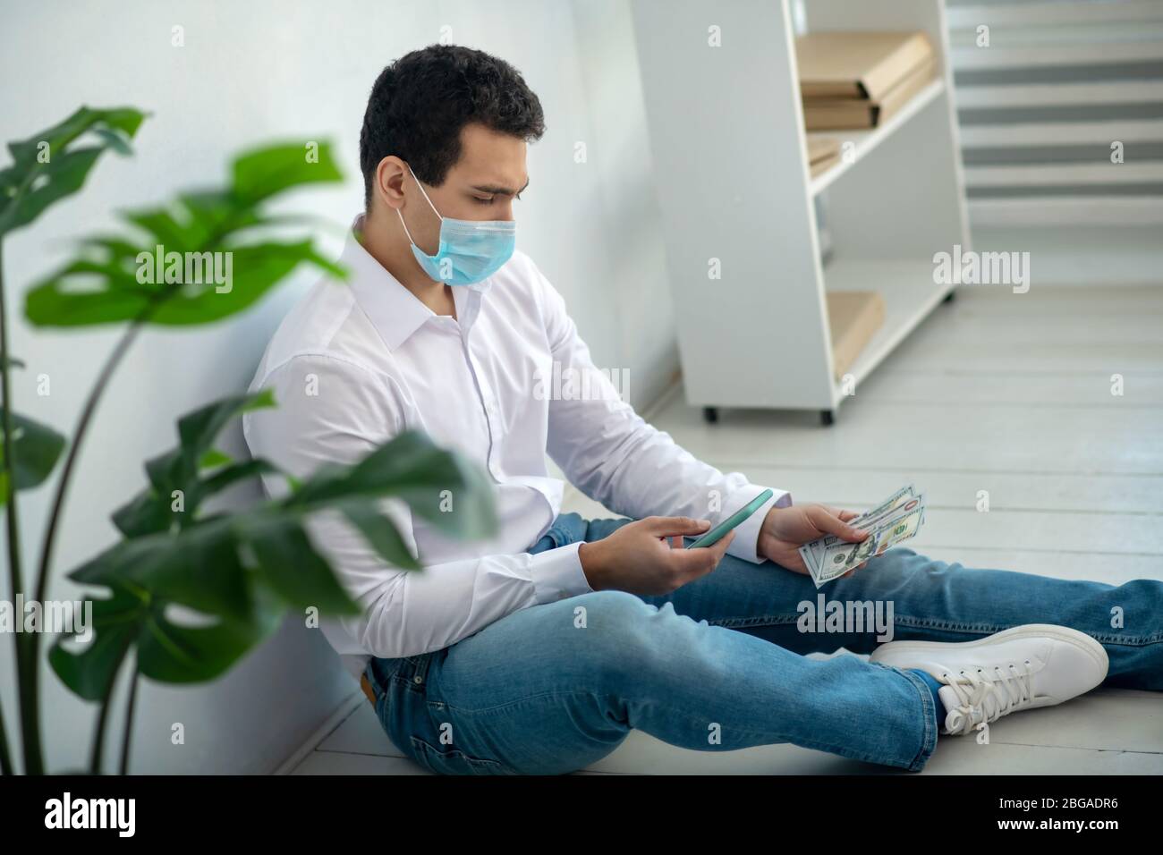 Man sitting on the floor and looking desperate Stock Photo - Alamy