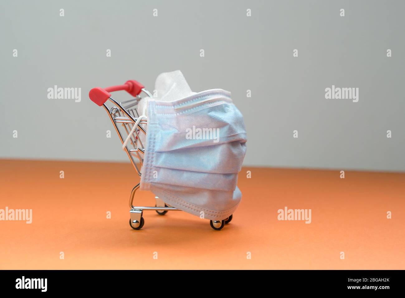 Shopping cart or trolley with medical face mask wrapped around it. Isolated. Conceptual. Stock Photo