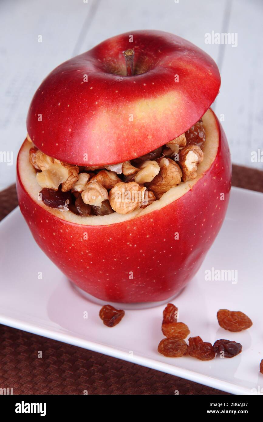 Apples with raisins and nuts on plate on table close up Stock Photo - Alamy