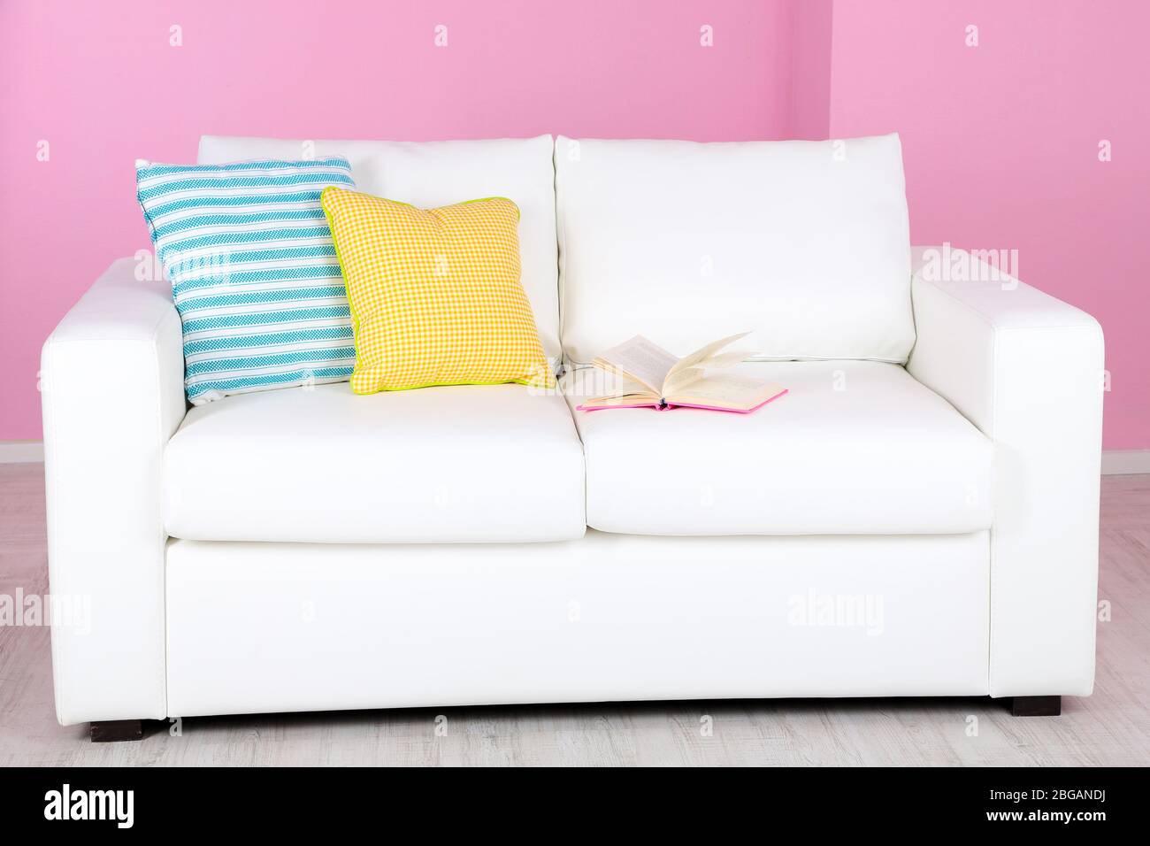 White sofa in room on pink background Stock Photo