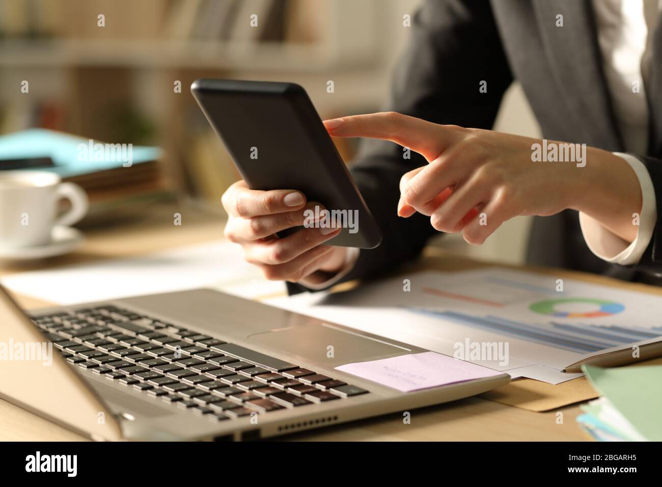 Close up of entrepreneur woman hands using smart phone at night at home Stock Photo