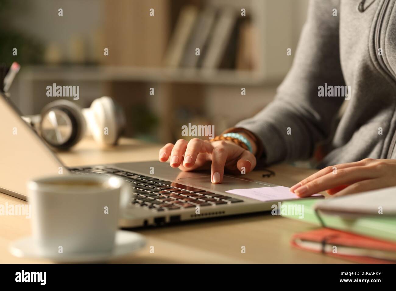 Close up of student girl hands using touchpad on laptop studying at night Stock Photo
